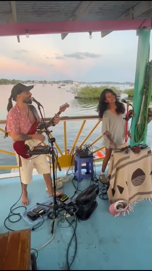 Live music duo performing on deck at sunset